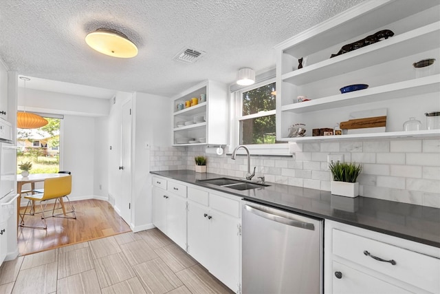 3104 Rexford Dr, Austin, TX 78723 - kitchen featuring stainless steel dishwasher, open shelves, a sink, dark countertops, and backsplash