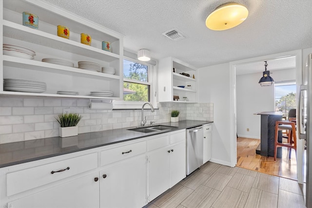 3104 Rexford Dr, Austin, TX 78723 - kitchen featuring open shelves, dishwasher, dark countertops, decorative backsplash, and white cabinets
