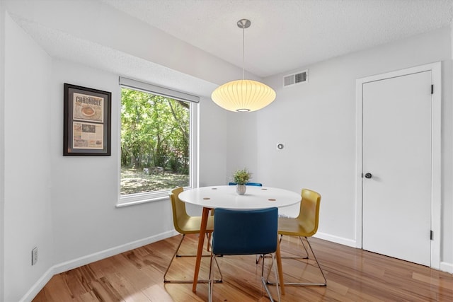 3104 Rexford Dr, Austin, TX 78723 - dining area featuring wood finished floors, baseboards, and a textured ceiling