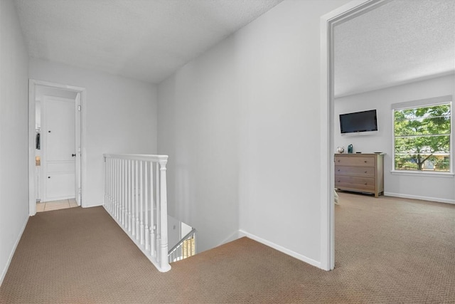 3104 Rexford Dr, Austin, TX 78723 - corridor featuring an upstairs landing, carpet flooring, baseboards, and a textured ceiling