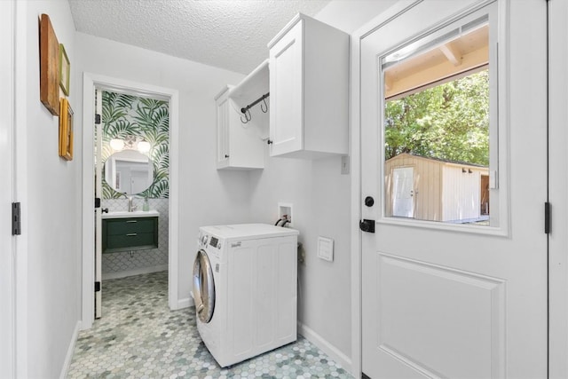3104 Rexford Dr, Austin, TX 78723 - laundry area featuring washer / dryer, cabinet space, and a textured ceiling