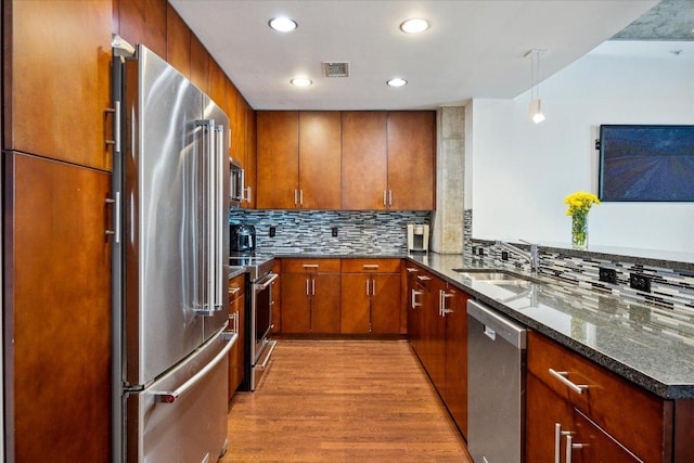 360 Nueces St Unit 3309, Austin, TX 78701 - kitchen with stainless steel appliances, a sink, light wood-style flooring, tasteful backsplash, and recessed lighting