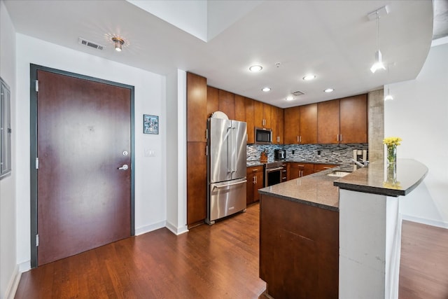 360 Nueces St Unit 3309, Austin, TX 78701 - kitchen with stainless steel appliances, a peninsula, dark wood-style floors, brown cabinets, and a sink