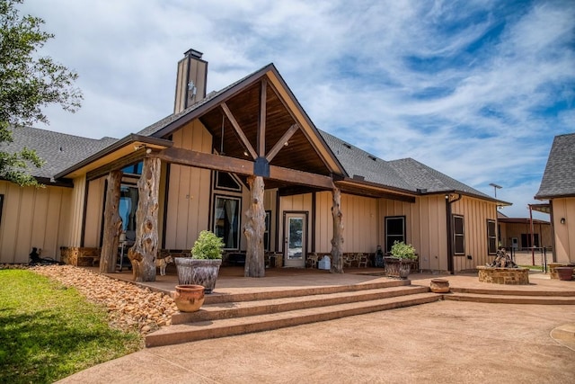2543 Fm 975, Caldwell, TX 77836 - rear view of house with board and batten siding, a chimney, a fire pit, and a patio area
