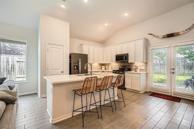 267 Razzmatazz Trl, Buda, TX 78610 - kitchen featuring appliances with stainless steel finishes, a sink, wood tiled floors, backsplash, and light countertops
