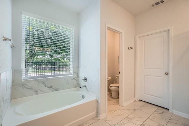267 Razzmatazz Trl, Buda, TX 78610 - bathroom featuring marble finish floors, a bath, toilet, and plenty of natural light