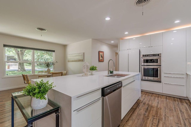 4714 Philco Dr, Austin, TX 78745 - kitchen featuring stainless steel appliances, a sink, light wood-style flooring, modern cabinets, and recessed lighting