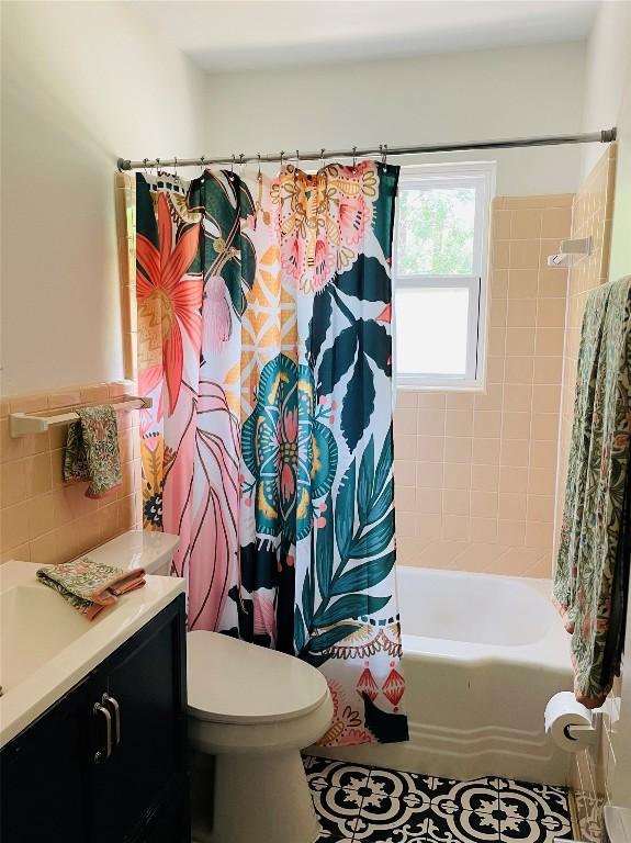 4714 Philco Dr, Austin, TX 78745 - bathroom with vanity, shower / bathtub combination with curtain, toilet, tile walls, and tile patterned floors