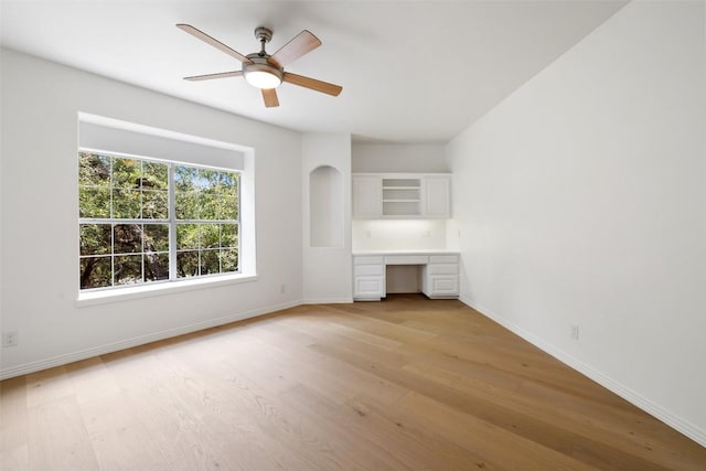 8311 Sumner Ct, Austin, TX 78733 - unfurnished living room featuring built in desk, light wood-type flooring, and a ceiling fan