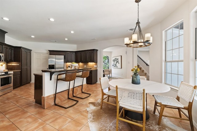 8311 Sumner Ct, Austin, TX 78733 - dining space featuring arched walkways, stairs, light tile patterned flooring, recessed lighting, and a chandelier