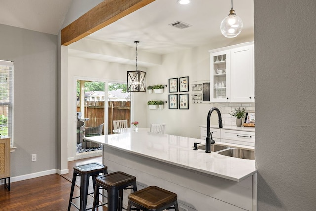 1609 Churchill Cv, Cedar Park, TX 78613 - kitchen with a sink, dark wood-type flooring, a breakfast bar, white cabinets, and glass insert cabinets