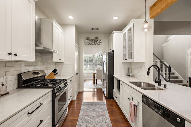 1609 Churchill Cv, Cedar Park, TX 78613 - kitchen with stainless steel appliances, a sink, wall chimney exhaust hood, white cabinets, and recessed lighting
