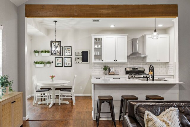1609 Churchill Cv, Cedar Park, TX 78613 - kitchen with wall chimney range hood, gas stove, tasteful backsplash, dark wood-style flooring, and recessed lighting