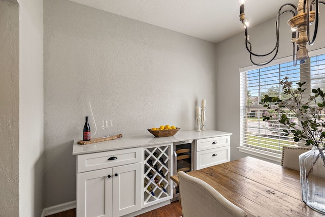 1609 Churchill Cv, Cedar Park, TX 78613 - dining room with beverage cooler, dark wood finished floors, a dry bar, and a textured wall