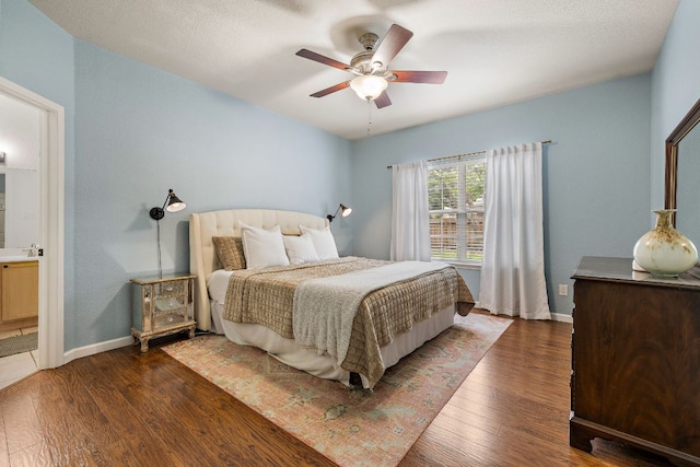 1609 Churchill Cv, Cedar Park, TX 78613 - bedroom featuring wood finished floors, baseboards, a sink, ensuite bath, and a ceiling fan