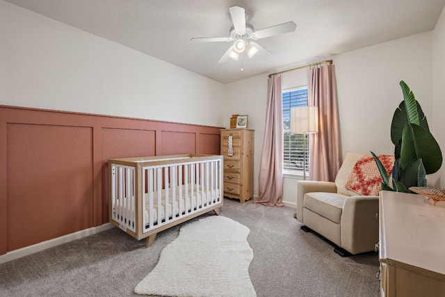 1609 Churchill Cv, Cedar Park, TX 78613 - bedroom featuring light colored carpet, a crib, a wainscoted wall, a ceiling fan, and a decorative wall