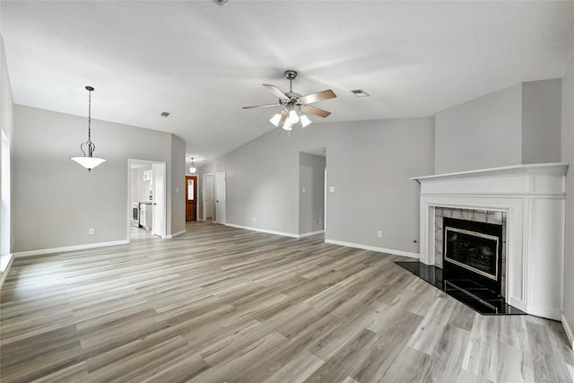 707 Shamrock Dr, Leander, TX 78641 - unfurnished living room with lofted ceiling, ceiling fan, light wood finished floors, a premium fireplace, and baseboards