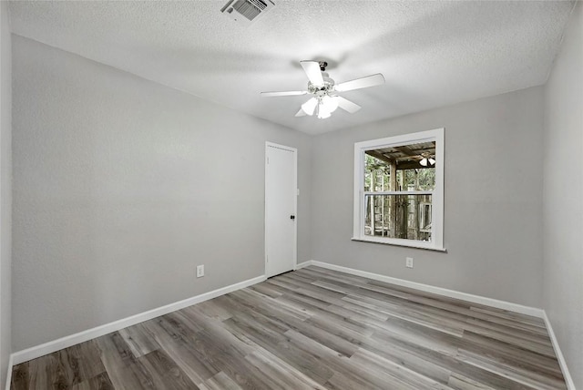 707 Shamrock Dr, Leander, TX 78641 - empty room featuring wood finished floors, baseboards, a textured ceiling, and a ceiling fan