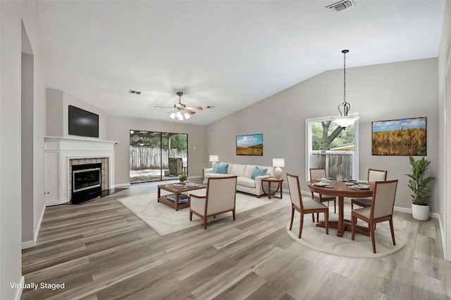 707 Shamrock Dr, Leander, TX 78641 - living area featuring light wood-style floors, baseboards, lofted ceiling, a fireplace, and a ceiling fan