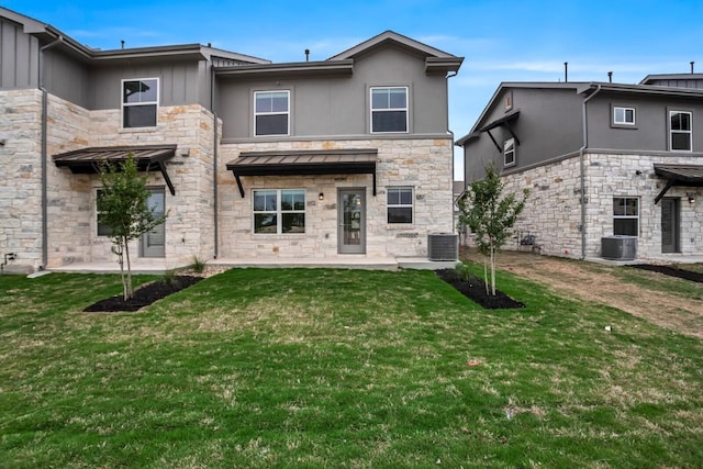2121 Local Rebel Loop, Leander, TX 78641 - back of house featuring stone siding, a lawn, and stucco siding