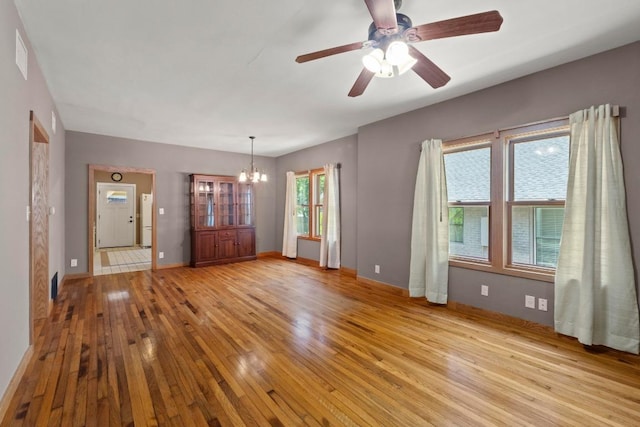 4314 Duval St, Austin, TX 78751 - spare room featuring light wood-style floors, a chandelier, and a ceiling fan