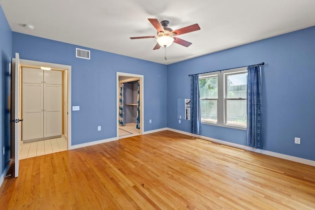 4314 Duval St, Austin, TX 78751 - unfurnished bedroom featuring light wood-style flooring, a walk in closet, and a ceiling fan