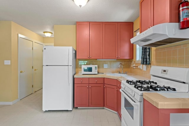 4314 Duval St, Austin, TX 78751 - kitchen with white appliances, under cabinet range hood, tile countertops, and backsplash