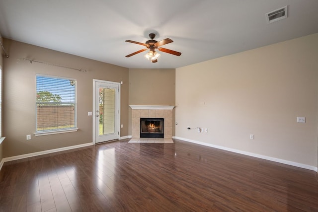 3809 Bronco Bend Loop, Austin, TX 78744 - unfurnished living room with ceiling fan, a tiled fireplace, wood finished floors, and baseboards