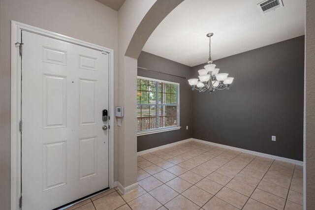 3809 Bronco Bend Loop, Austin, TX 78744 - entryway with arched walkways, a chandelier, light tile patterned floors, and baseboards