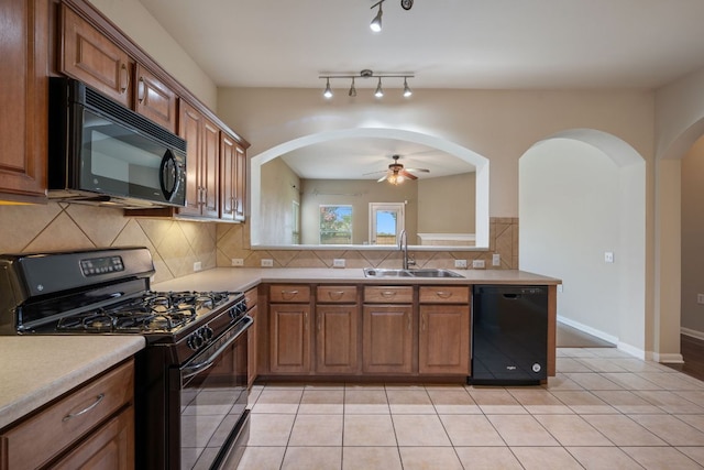 3809 Bronco Bend Loop, Austin, TX 78744 - kitchen with black appliances, a sink, a ceiling fan, arched walkways, and brown cabinetry