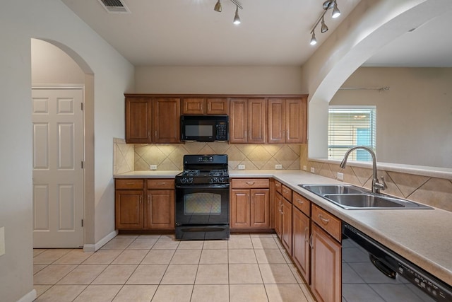 3809 Bronco Bend Loop, Austin, TX 78744 - kitchen with black appliances, a sink, arched walkways, and brown cabinetry