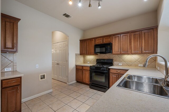 3809 Bronco Bend Loop, Austin, TX 78744 - kitchen featuring black appliances, a sink, light tile patterned floors, light countertops, and arched walkways