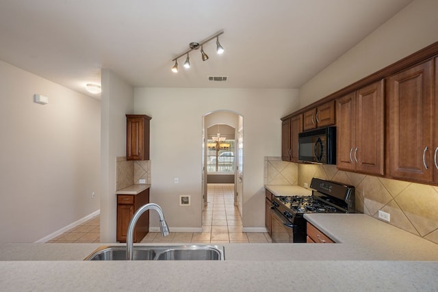 3809 Bronco Bend Loop, Austin, TX 78744 - kitchen featuring black appliances, a sink, light tile patterned floors, light countertops, and backsplash