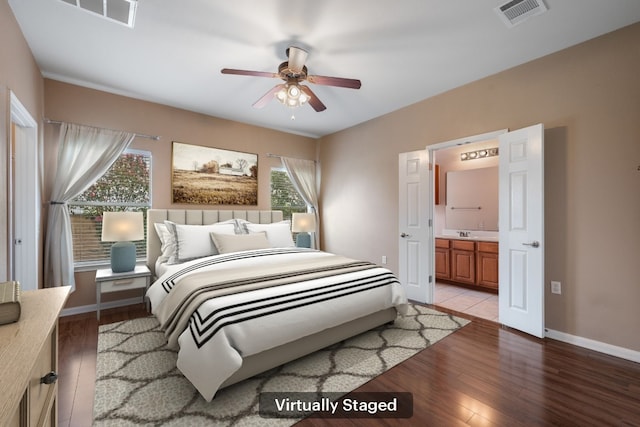 3809 Bronco Bend Loop, Austin, TX 78744 - bedroom with light wood-style flooring, baseboards, ensuite bath, and ceiling fan