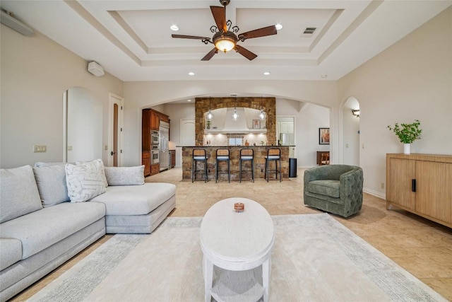 12529 Verandah Ct, Austin, TX 78726 - living room featuring arched walkways, a ceiling fan, recessed lighting, and a tray ceiling
