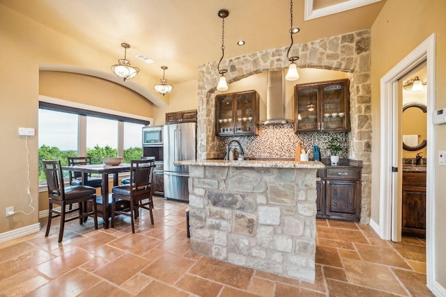12529 Verandah Ct, Austin, TX 78726 - kitchen featuring wall chimney exhaust hood, stainless steel appliances, dark brown cabinetry, and stone tile flooring