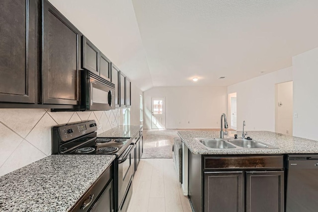 14309 Deaf Smith Blvd, Austin, TX 78725 - kitchen featuring appliances with stainless steel finishes, a sink, tasteful backsplash, open floor plan, and an island with sink