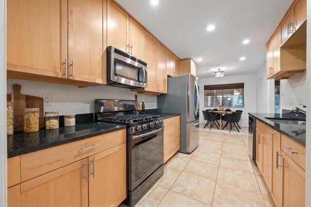 7701 Lowdes Dr, Austin, TX 78745 - kitchen featuring stainless steel appliances, a sink, recessed lighting, light tile patterned floors, and dark stone counters