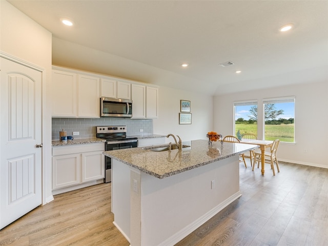 102 Sandpiper Dr, Bastrop, TX 78602 - kitchen with appliances with stainless steel finishes, white cabinetry, light wood finished floors, and recessed lighting