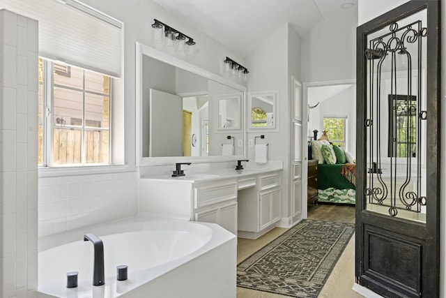 9205 Amanda Dr, Austin, TX 78729 - ensuite bathroom with a bath, vanity, and wood finished floors
