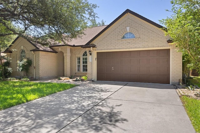 9205 Amanda Dr, Austin, TX 78729 - view of front of house featuring an attached garage, concrete driveway, and brick siding