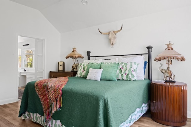 9205 Amanda Dr, Austin, TX 78729 - bedroom with wood finished floors, lofted ceiling, and ensuite bath