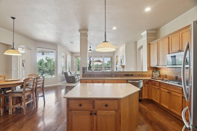 816 Drifting Wind Run, Dripping Springs, TX 78620 - kitchen featuring appliances with stainless steel finishes, arched walkways, a sink, dark wood-style flooring, and light stone counters