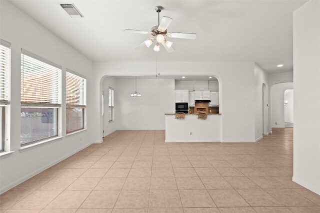 260 Kiras Ct, Austin, TX 78737 - unfurnished living room with arched walkways, a ceiling fan, recessed lighting, baseboards, and light tile patterned floors