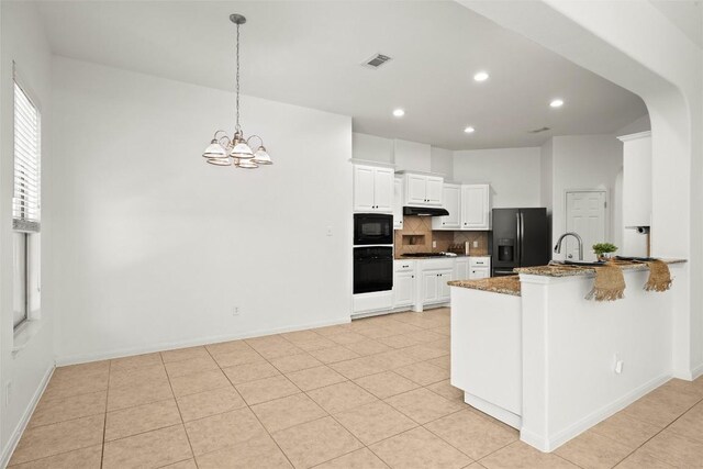 260 Kiras Ct, Austin, TX 78737 - kitchen with black appliances, backsplash, a chandelier, dark stone counters, and a peninsula