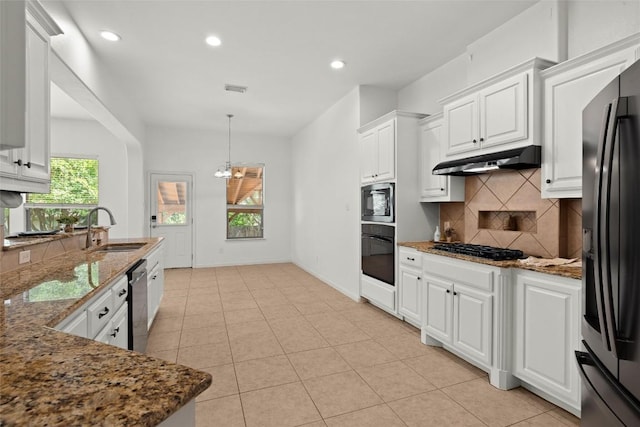 260 Kiras Ct, Austin, TX 78737 - kitchen featuring appliances with stainless steel finishes, a sink, under cabinet range hood, decorative backsplash, and dark stone counters