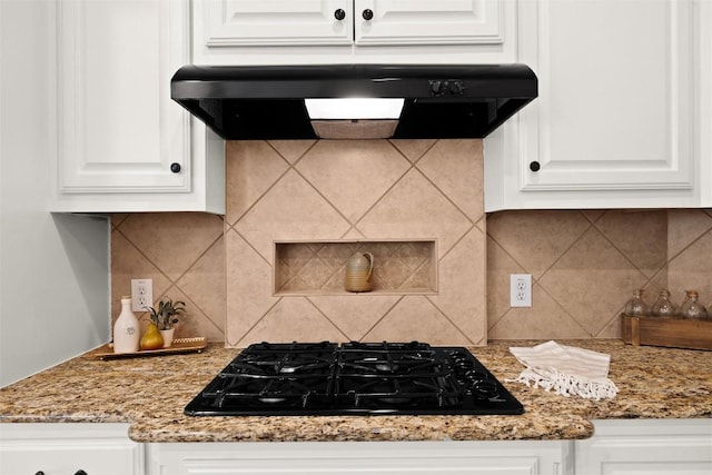 260 Kiras Ct, Austin, TX 78737 - kitchen featuring under cabinet range hood, black gas stovetop, white cabinetry, tasteful backsplash, and light stone countertops