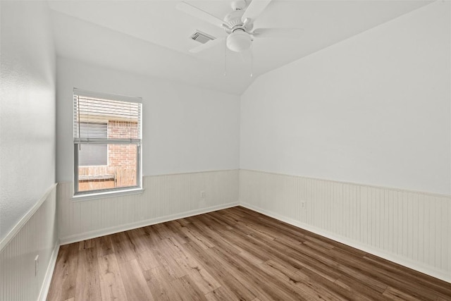 260 Kiras Ct, Austin, TX 78737 - unfurnished room with wood finished floors, wainscoting, ceiling fan, and lofted ceiling