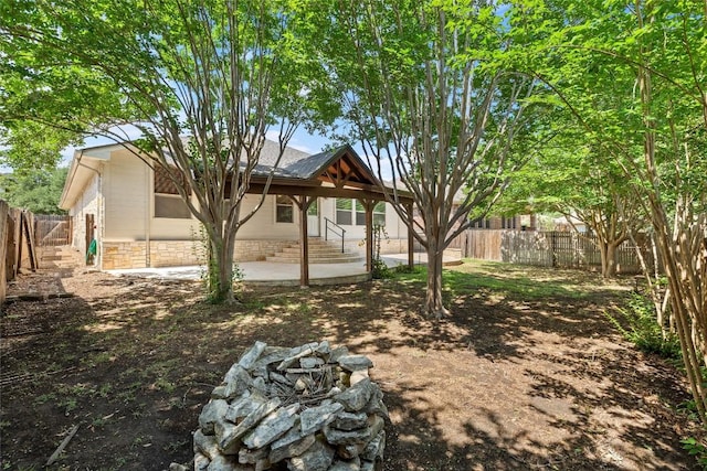 260 Kiras Ct, Austin, TX 78737 - back of house featuring a fire pit, a patio, a fenced backyard, and stone siding