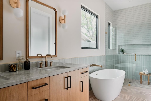 7809 Hardy Dr, Austin, TX 78757 - bathroom featuring double vanity, tile patterned floors, a freestanding tub, tile walls, and a tile shower